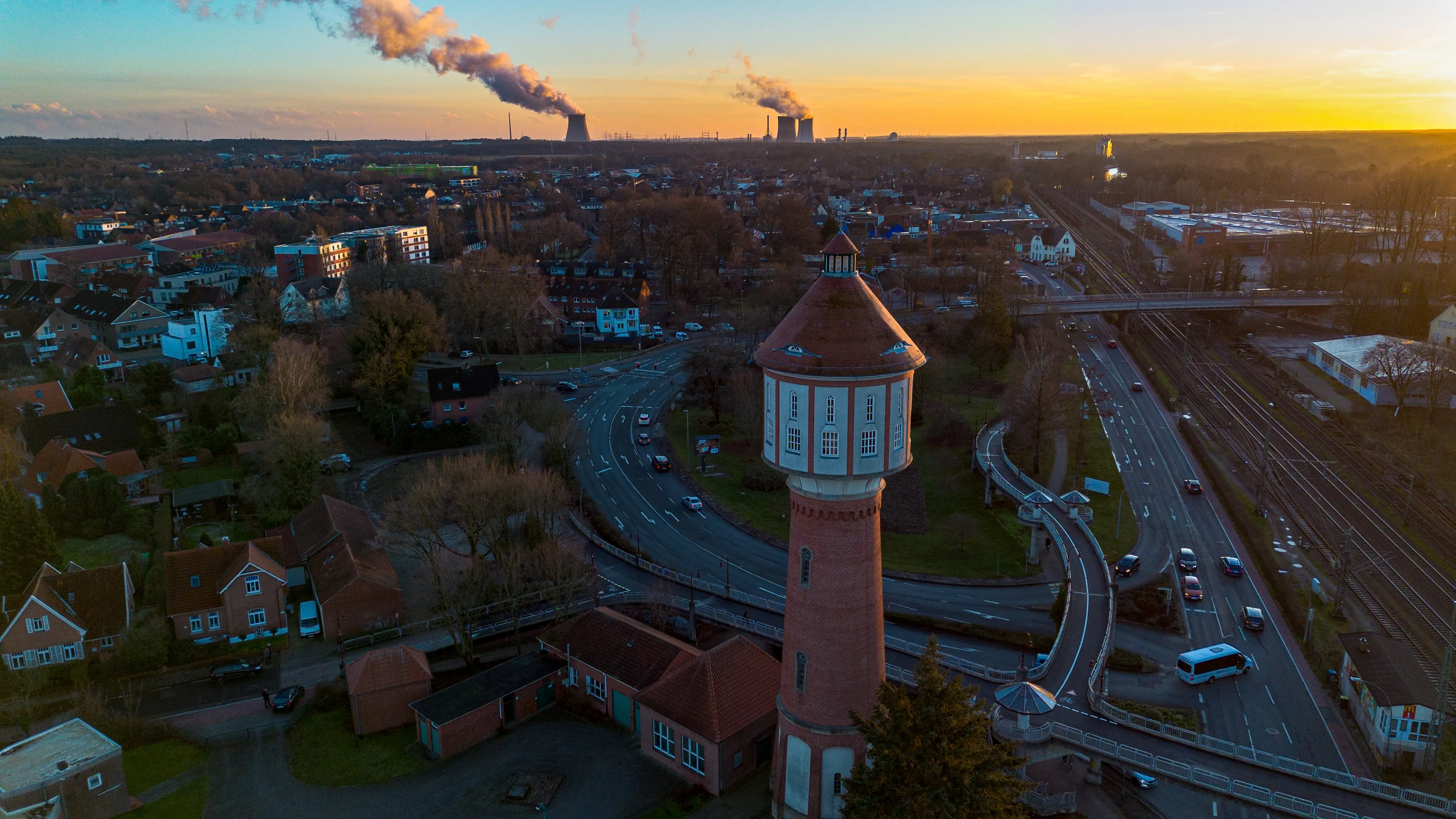 Wasserturm Lingen im Abendlicht von oben, dahinter Stadt und Kraftwerk – Drohnen-Luftaufnahme aus dem Emsland